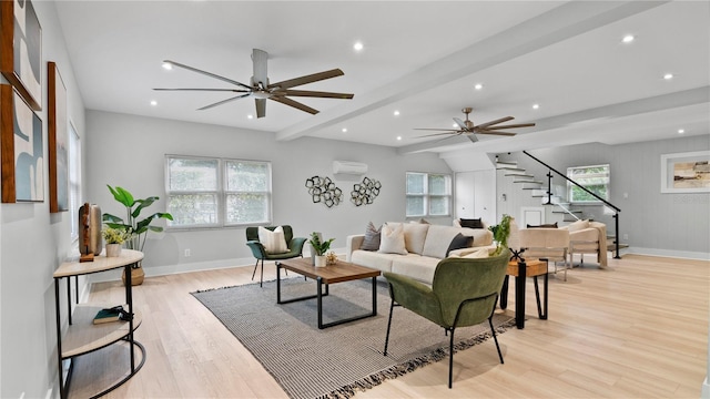 living room featuring a wall mounted air conditioner, a healthy amount of sunlight, and light hardwood / wood-style flooring