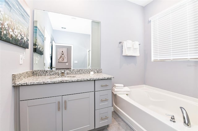 bathroom featuring vanity, a bath, and tile patterned floors