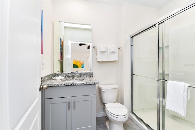 bathroom featuring a shower with door, vanity, tile patterned floors, and toilet