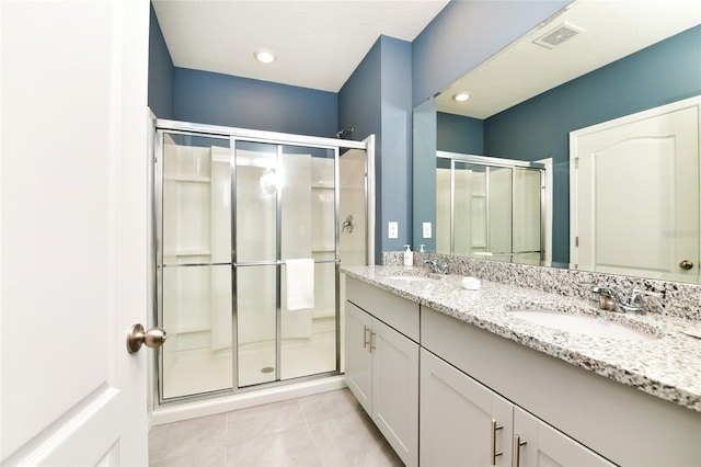 bathroom featuring a shower with door, vanity, and tile patterned flooring