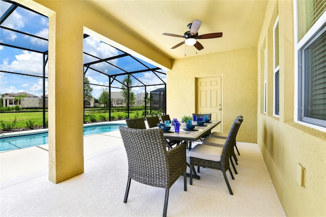 view of pool with glass enclosure and a patio area