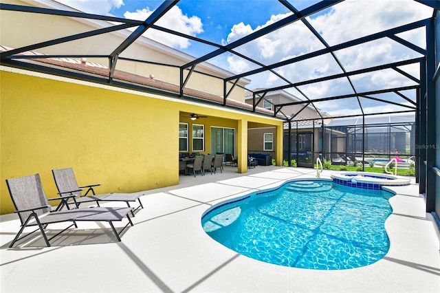 view of pool featuring an in ground hot tub, ceiling fan, a patio, and glass enclosure