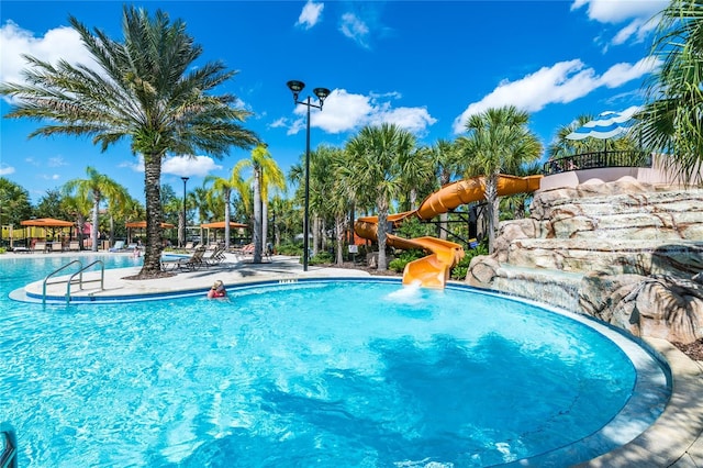 view of pool with a playground and a water slide