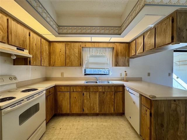 kitchen featuring sink, white appliances, and kitchen peninsula