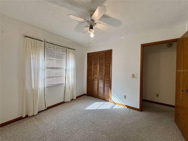 unfurnished bedroom with a textured ceiling, a closet, ceiling fan, and carpet flooring