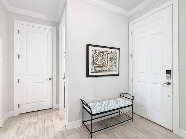 foyer with ornamental molding and light hardwood / wood-style flooring