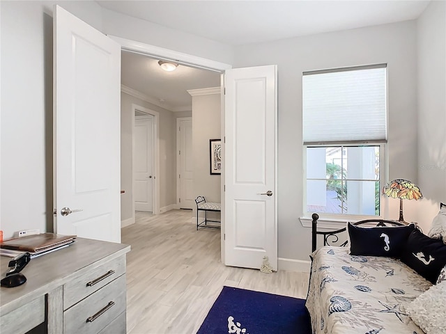 bedroom featuring crown molding and light hardwood / wood-style flooring