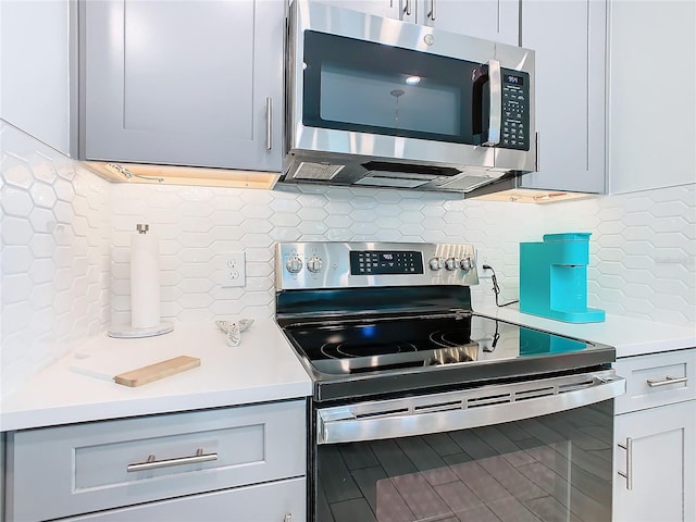 kitchen featuring appliances with stainless steel finishes, gray cabinets, and backsplash