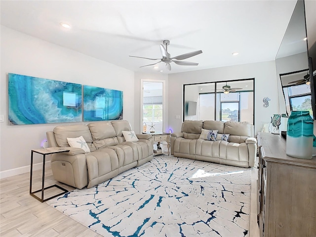 living room featuring ceiling fan and light hardwood / wood-style floors