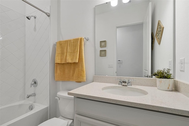 full bathroom featuring vanity, tiled shower / bath, and toilet