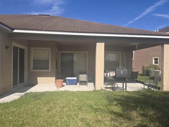 rear view of property with a yard, central air condition unit, and a patio area