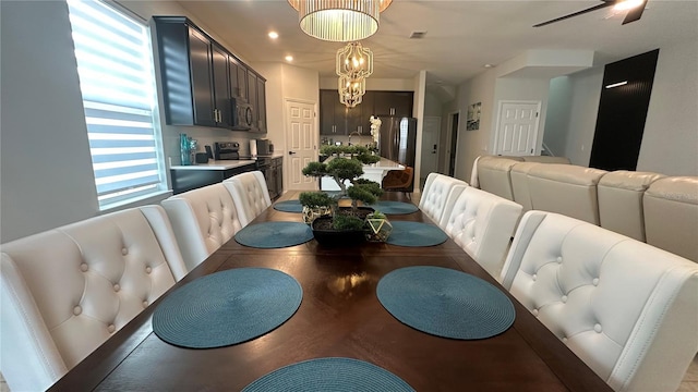 dining area featuring ceiling fan with notable chandelier