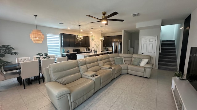 living room with sink, light tile patterned floors, and ceiling fan