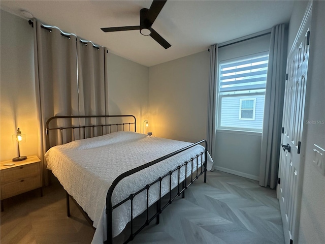 bedroom with light parquet floors, ceiling fan, and a closet