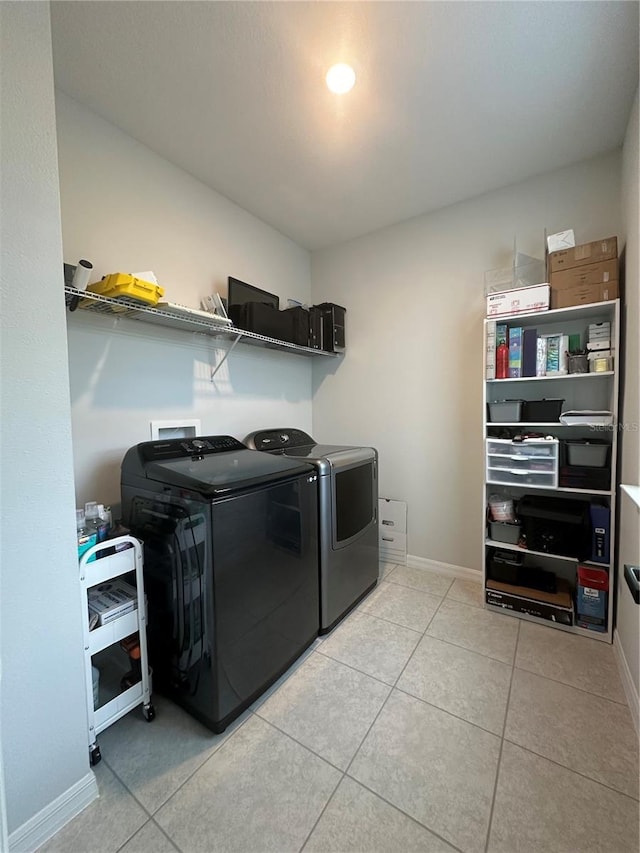 laundry area featuring light tile patterned floors and washer and clothes dryer