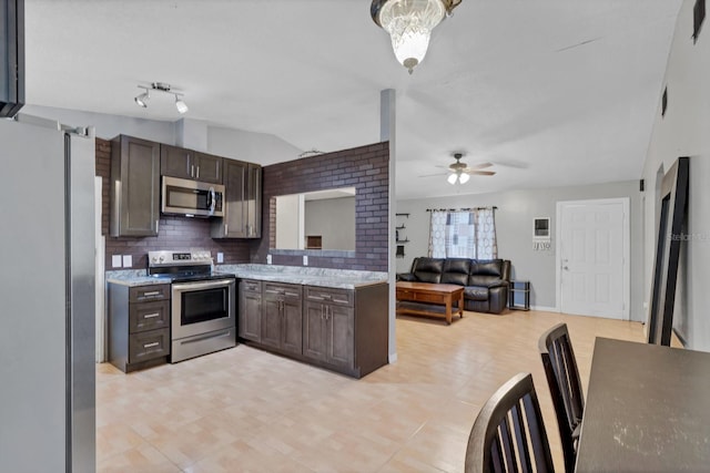 kitchen featuring dark brown cabinetry, lofted ceiling, ceiling fan, stainless steel appliances, and decorative backsplash