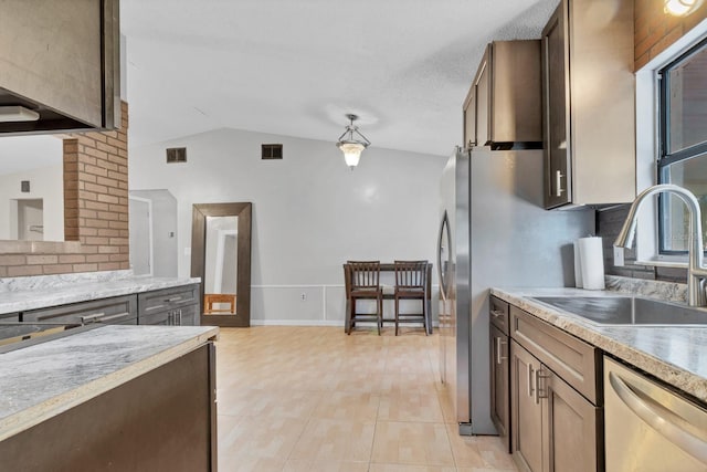 kitchen with sink, light tile patterned floors, decorative backsplash, vaulted ceiling, and stainless steel dishwasher