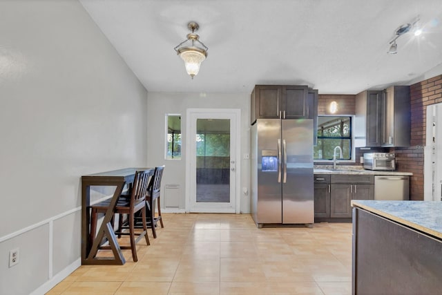 kitchen featuring appliances with stainless steel finishes, sink, and dark brown cabinets