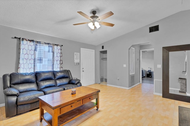 living room featuring a textured ceiling and ceiling fan