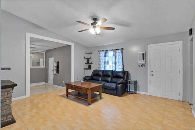 living room featuring lofted ceiling, a textured ceiling, ceiling fan, and light tile patterned flooring