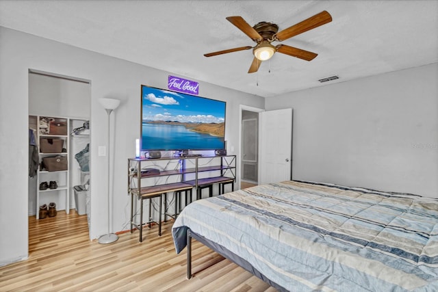 bedroom with hardwood / wood-style flooring, ceiling fan, and a textured ceiling