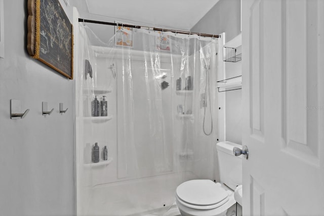 bathroom with curtained shower and toilet