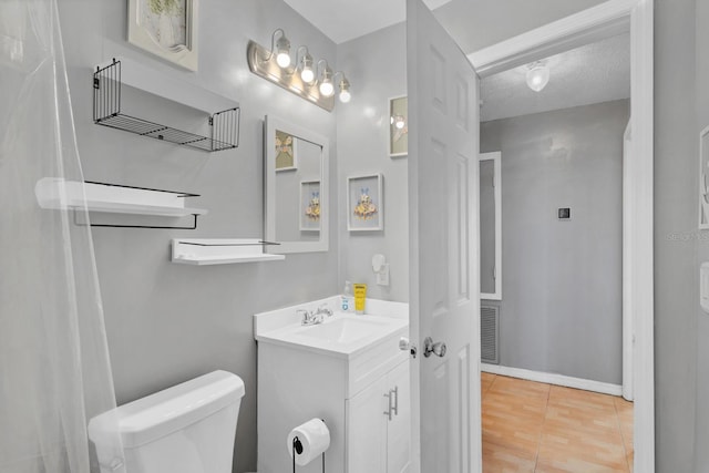 bathroom with vanity, tile patterned flooring, a textured ceiling, and toilet