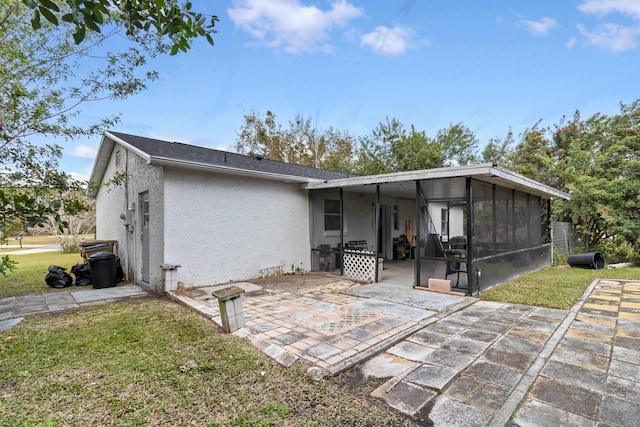 rear view of property with a sunroom, a yard, and a patio area