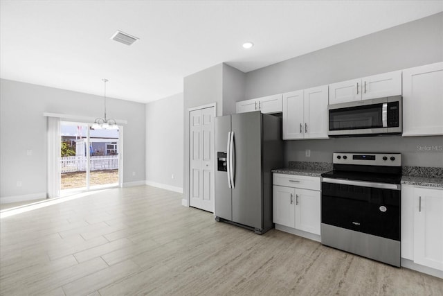 kitchen featuring white cabinetry, stainless steel appliances, decorative light fixtures, and a chandelier