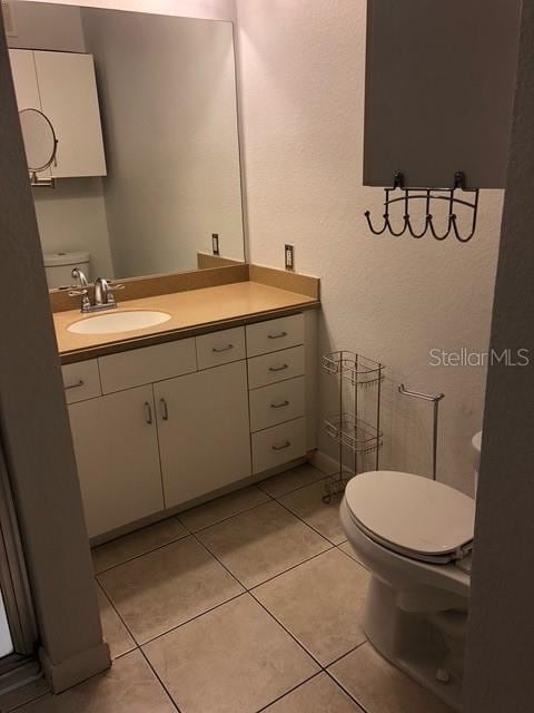 bathroom with vanity, toilet, and tile patterned flooring