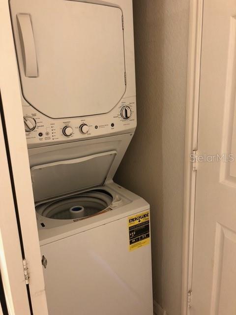 clothes washing area featuring stacked washer / drying machine