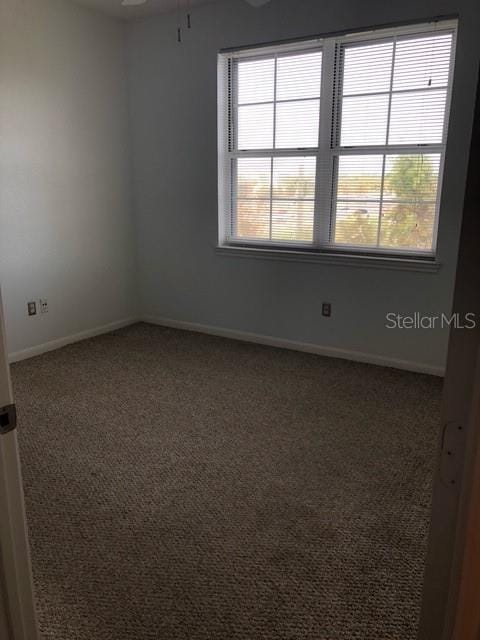 empty room with ceiling fan and carpet flooring