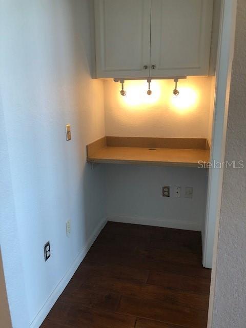 interior space with white cabinetry and dark wood-type flooring