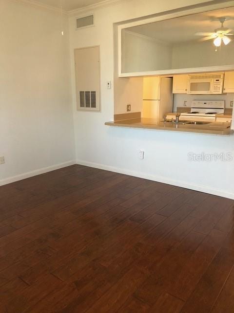 unfurnished living room with dark wood-type flooring, ceiling fan, and ornamental molding