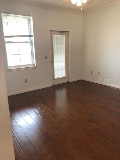 spare room with dark hardwood / wood-style flooring, ornamental molding, and ceiling fan