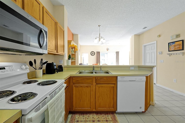 kitchen featuring light tile patterned flooring, sink, kitchen peninsula, pendant lighting, and white appliances