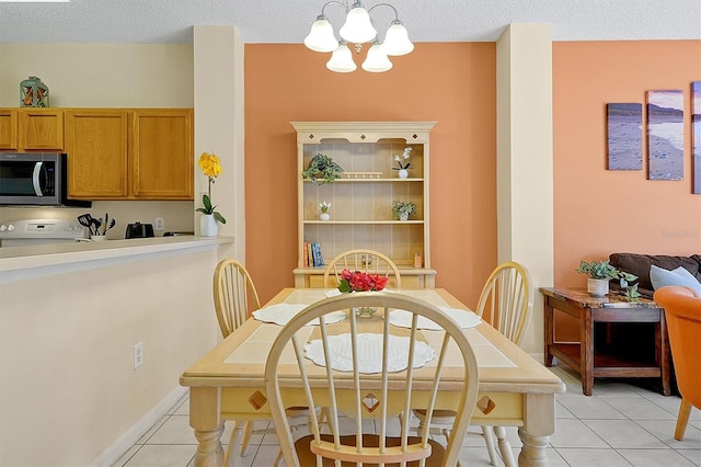 dining area featuring light tile patterned flooring, an inviting chandelier, and a textured ceiling