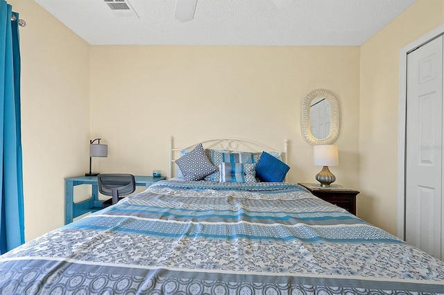 bedroom with a textured ceiling and ceiling fan