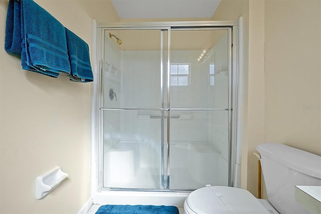 bathroom with an enclosed shower and toilet