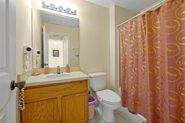 bathroom with vanity, toilet, tile patterned flooring, and a textured ceiling