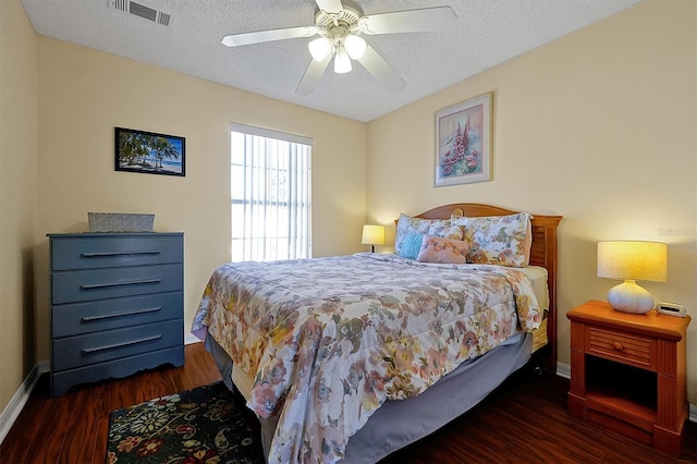 bedroom with dark wood-type flooring, ceiling fan, and a textured ceiling