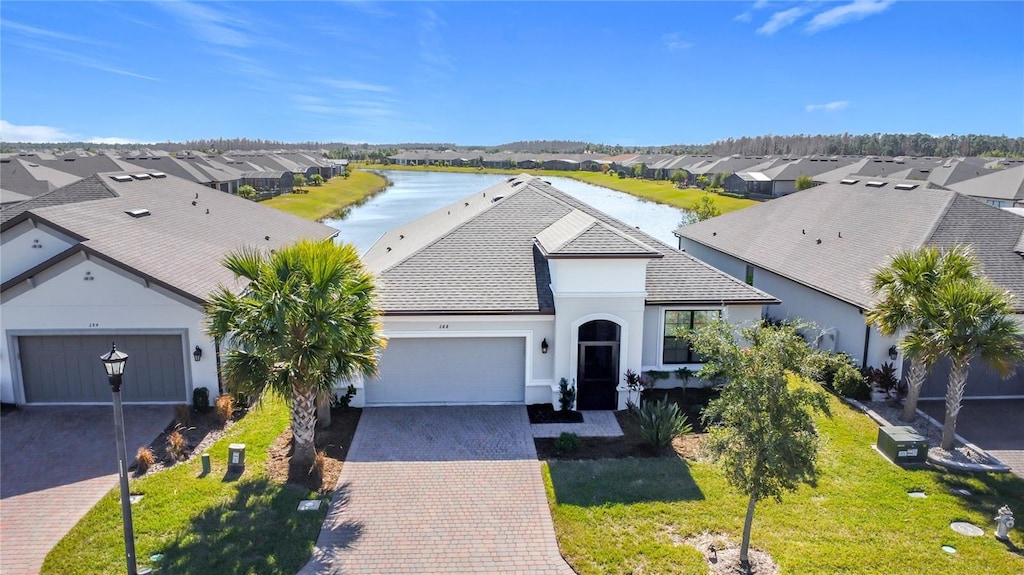 view of front of property with a water view, a garage, and a front yard