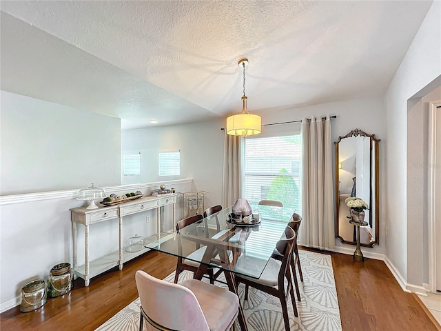 dining room featuring hardwood / wood-style flooring and a textured ceiling