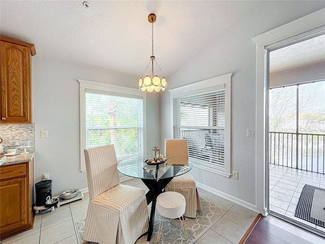 tiled dining room with lofted ceiling