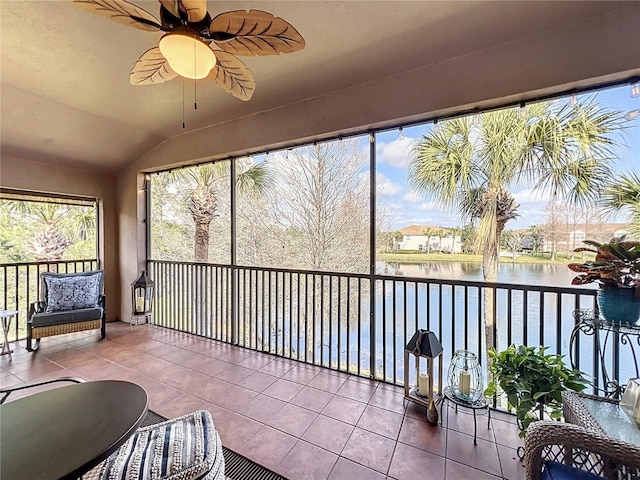 sunroom / solarium with a water view, ceiling fan, plenty of natural light, and vaulted ceiling