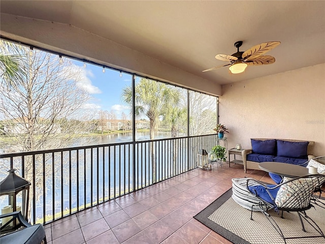 sunroom with a water view and ceiling fan