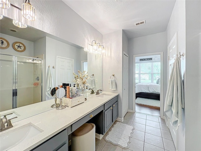 bathroom with vanity, an enclosed shower, and tile patterned floors