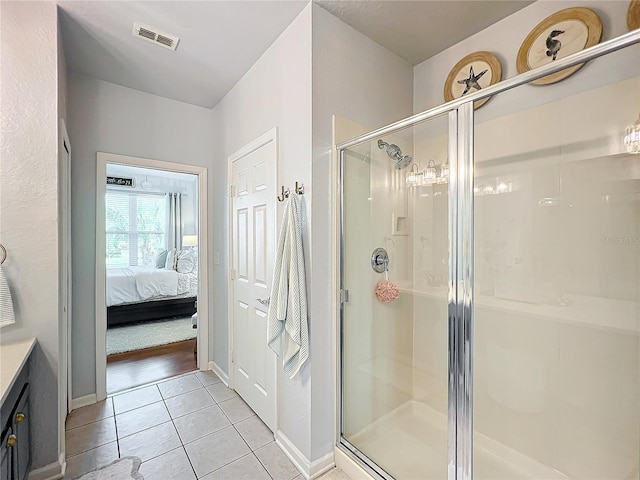 bathroom featuring tile patterned flooring and an enclosed shower