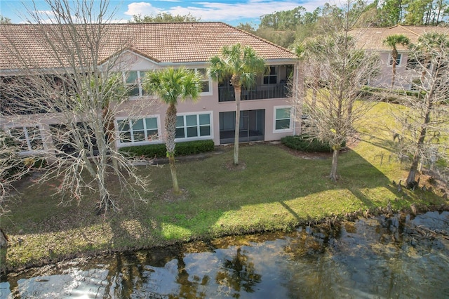 exterior space with a water view and a lawn