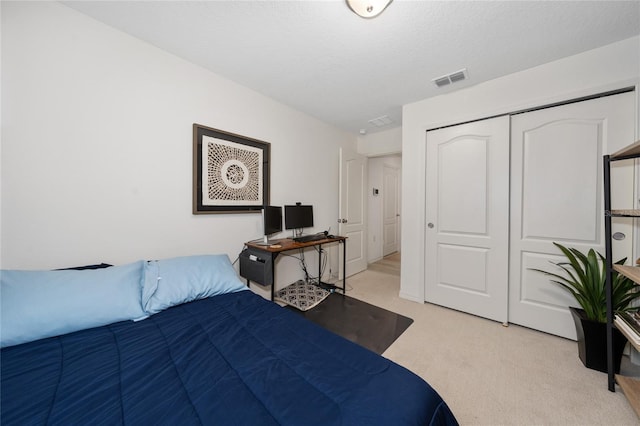 carpeted bedroom with a closet and a textured ceiling